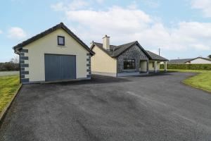 a detached house with a garage on a driveway at Castle View in Oughterard