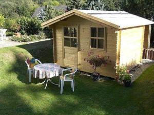 a table and chairs in a yard with a shed at Haus-Schneider-grosse-Ferienwohnung in Wolfshagen