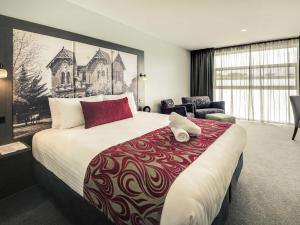 a hotel room with a large bed and a chair at Mercure Warragul in Warragul +67 photos