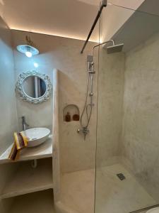 a bathroom with a shower and a sink and a mirror at Ktima Zaxarias in Kokkala