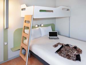 a bedroom with a bunk bed with a laptop on it at ibis budget Goussainville Charles de Gaulle in Goussainville