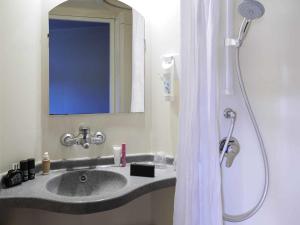 a bathroom with a sink and a shower with a mirror at ibis budget Albi Terssac in Terssac +24 photos