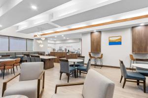 a waiting room with tables and chairs at Sonesta ES Suites Phoenix Goodyear in Goodyear