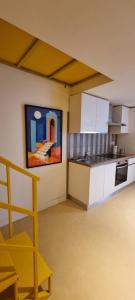 a kitchen with white cabinets and a painting on the wall at La Dimora del Cardinale in Naples