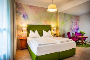 a bedroom with a large bed with a colorful wall at Hotel Allmer in Bad Gleichenberg +43 photos