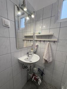 a white bathroom with a sink and a mirror at Erika Vendégház in Igal +6 photos