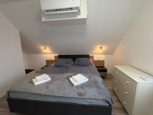 a bedroom with a bed with two towels on it at Erika Vendégház in Igal