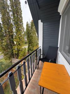 a porch with a wooden table and a chair at Erika Vendégház in Igal