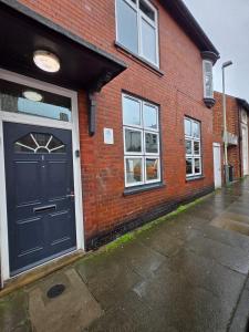 a brick building with a blue door and windows at Levy Nook 6 in Darlington