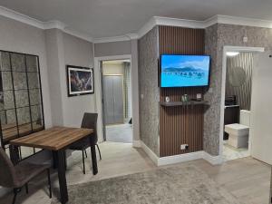 a living room with a table and a television on a wall at Levy Nook 6 in Darlington