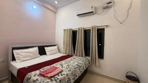 a bedroom with a bed and a window at Utkarsh Palace And Restaurant in Ayodhya Ghā