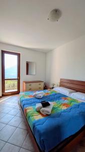 a bedroom with a large bed with a colorful blanket at Bosco Di Lago in Solto Collina