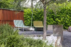 two chairs sitting in a yard next to a fence at Bosco Di Lago in Solto Collina +5 photos