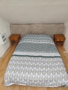 a bed in a room with two wooden tables at Studio Dennebroeucq in Dennebroeucq