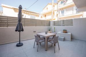 a table and chairs and an umbrella on a patio at Agora Luxury Suites in Lixouri