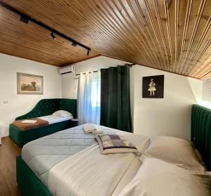 a bedroom with two beds and a wooden ceiling at Lakeview Escape Koman in Koman
