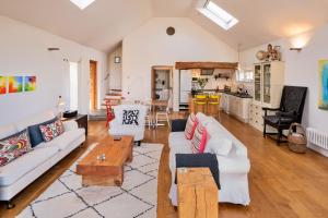 a living room with a white couch and a table at Finest Retreats - Mill Barn By The Stream in West Lydford