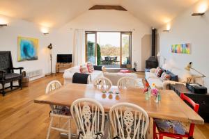 a living room with a wooden table and chairs at Finest Retreats - Mill Barn By The Stream in West Lydford