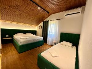 a bedroom with two beds and a window at Lakeview Escape Koman in Koman