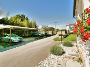 a house with cars parked in a driveway at Room PARADINOVIĆ in Zambratija