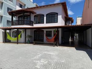 a building with two hammocks in front of it at Casa da Dinda102 in Rio das Ostras