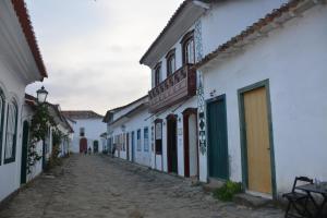 an alley with white buildings and a cobblestone street at Pousada Arte Colonial - Casarão Histórico do Séc XVIII - Lancha Própria in Paraty