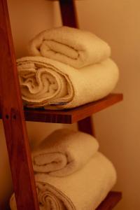 a stack of towels on a wooden shelf at Finca La Marta - El Cortijo Wine Lodge in Capilla del Monte +55 photos