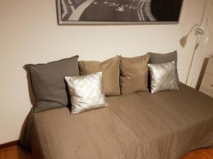 ein Bett mit drei Kissen darüber in der Unterkunft Regina Apartment in Chiavenna
