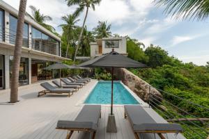 an infinity pool with chairs and an umbrella next to a resort at Palm Stone Villa in Haad Pleayleam