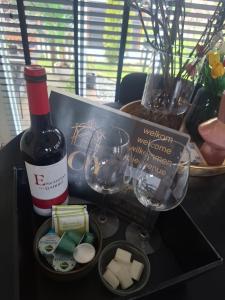 a bottle of wine and glasses on a table at JOY Boutique Chalet Berkhout - Hoorn in De Hulk
