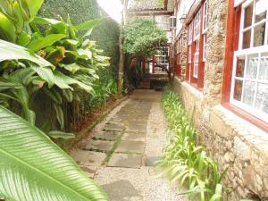 an alley in a building with plants on the side at Pousada Arte Colonial - Casarão Histórico do Séc XVIII - Lancha Própria in Paraty