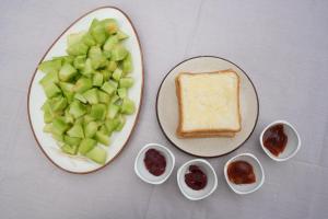 a plate of food with apples and bread and dips at The Windbloom - Himalayan Farm Stay in Mukteshwar +50 photos