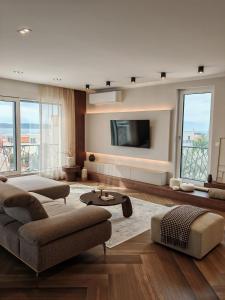 a living room with a couch and a tv at Mare Vista Rooftop Penthouse Sea View & Private Jacuzzi in Trogir