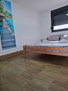 a bedroom with a bed and a painting on the wall at Sap Pool House in Ritopek +12 photos