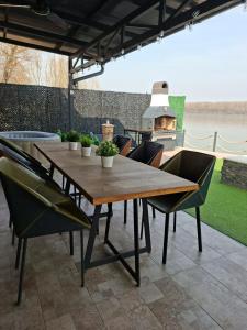 a wooden table and chairs on a patio with a grill at Sap Pool House in Ritopek