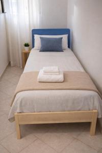 a bed with a blue head board with two towels on it at A Mare in Vasto