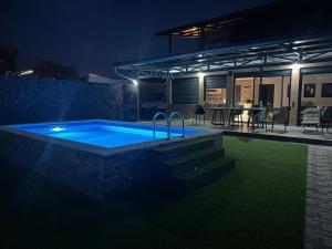 a swimming pool at night with a house at Sap Pool House in Ritopek