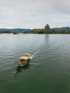 a small boat on a large body of water at Atma Villas Hotel Boutique Guatapé in Guatapé +45 photos