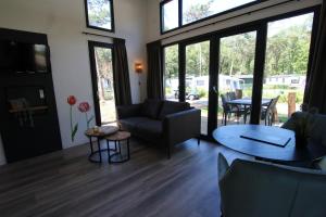 a living room with a couch and a table at Knusse Tiny House in de natuur in Baarle-Nassau