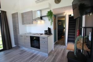 a kitchen with a sink and a stove top oven at Knusse Tiny House in de natuur in Baarle-Nassau +13 photos