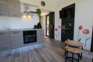 a kitchen with a counter and a table in it at Knusse Tiny House in de natuur in Baarle-Nassau