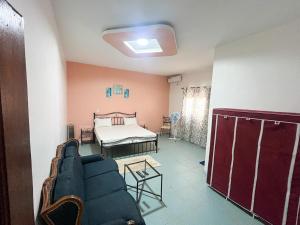a living room with a bed and a couch at Gite de la savane in Sindia +56 photos