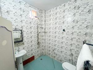 a white bathroom with a sink and a toilet at Gite de la savane in Sindia