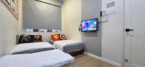 a hospital room with two beds and a flat screen tv at Skudai - The9 Homestay 1min UTM, near Sutera Mall, Paradigm Mall, Senai airport in Skudai