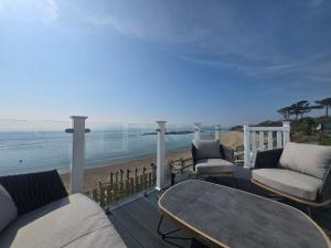 a balcony with chairs and a table and the beach at Pemberton Avon pitch 30 Creek Caravan Park dog friendly in Ringstead