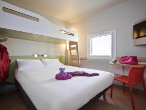 a bedroom with a bed with a teddy bear on it at ibis budget Pontault Combault RN4 Marne La Vallée in Pontault-Combault +50 photos