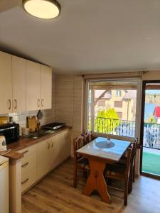 a kitchen with a table with chairs and a window at U Władzia in Gowidlino