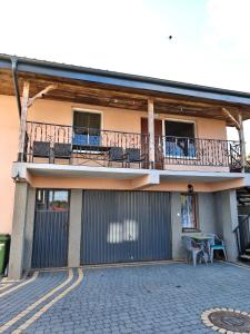 a building with a balcony with chairs and a table at U Władzia in Gowidlino