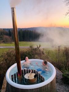 two people in a jacuzzi tub in a field at Weitblick am Mangfalltal in Feldkirchen-Westerham