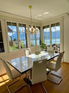 a dining room with a glass table and chairs at Mon Bijou Chalet au Lac Alpin in Thun +33 photos
